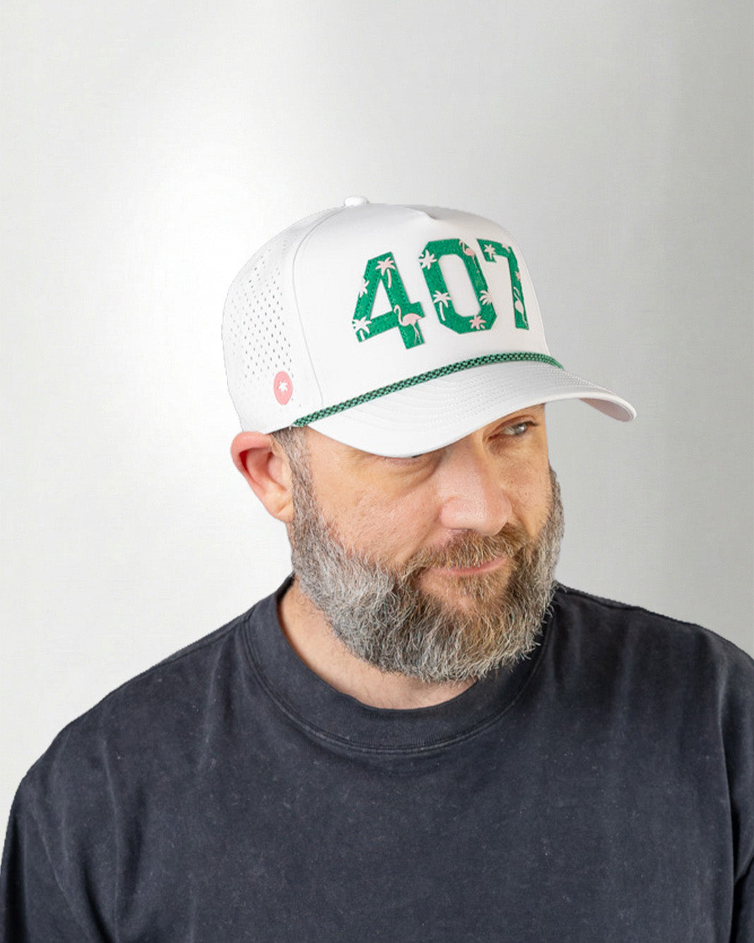 Man wearing a white cap with green text on a gray background