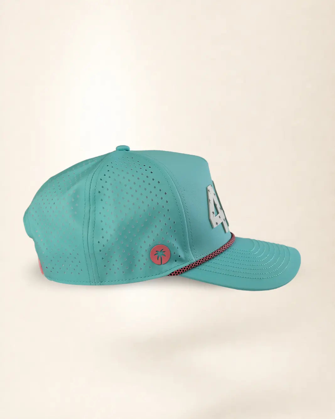 A turquoise blue baseball cap with perforated side panels, featuring a silver '4' on the side, a small red circular palm tree logo, and a red and black striped detail on the brim, set against a plain beige background.