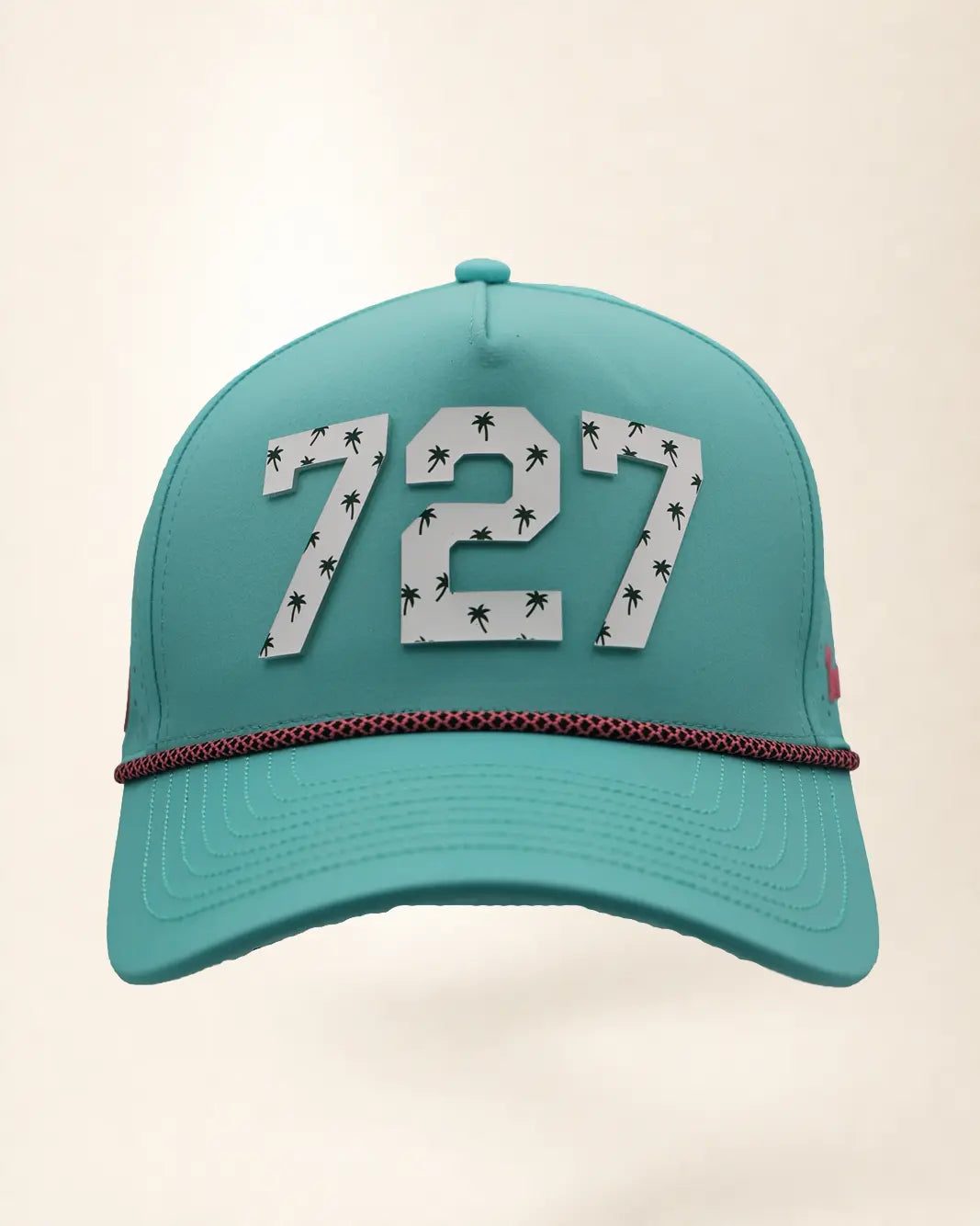 The 727 Signature Hat (Teal), front view: white raised 727 with small palm print on a teal crown, pink and black rope along the brim.