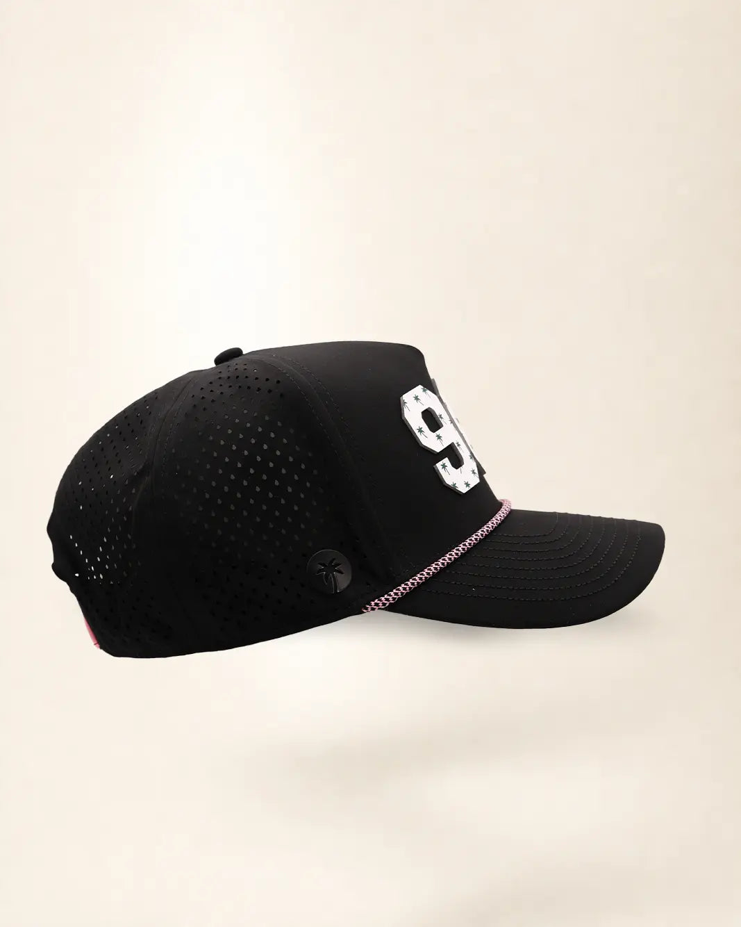 The 904 Signature Hat (Black), right side view: perforated side panel, palm badge, pink and white rope, edge of the white 904.