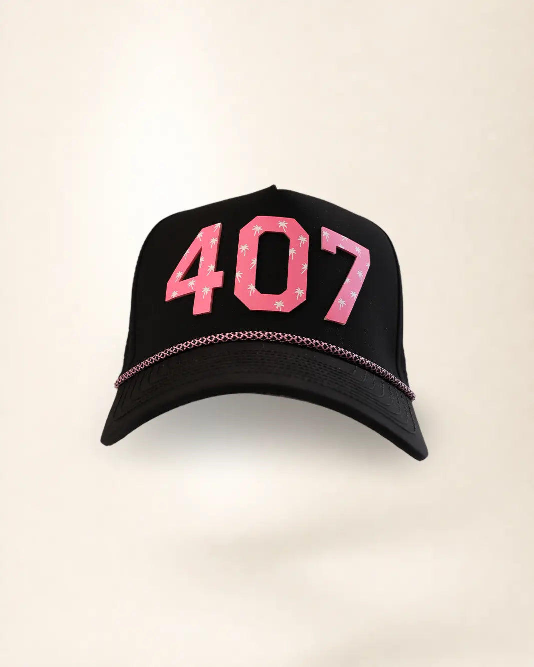 A black baseball cap featuring the number '407' in pink with white palm patterns on the front, and a thin pink chain detail along the edge of the brim, set against a plain off-white background.