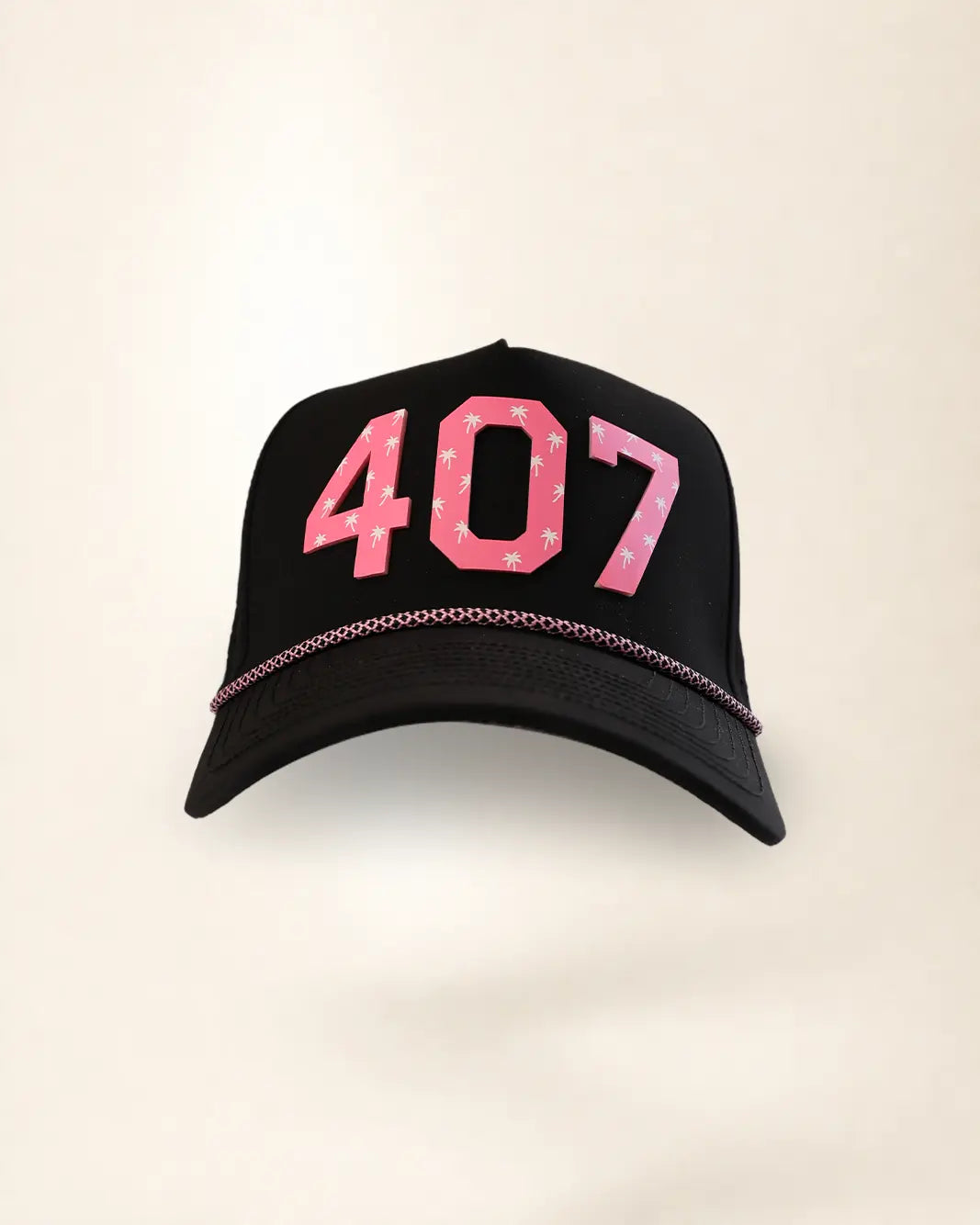 A black baseball cap featuring the number '407' in pink with white palm patterns on the front, and a thin pink chain detail along the edge of the brim, set against a plain off-white background.