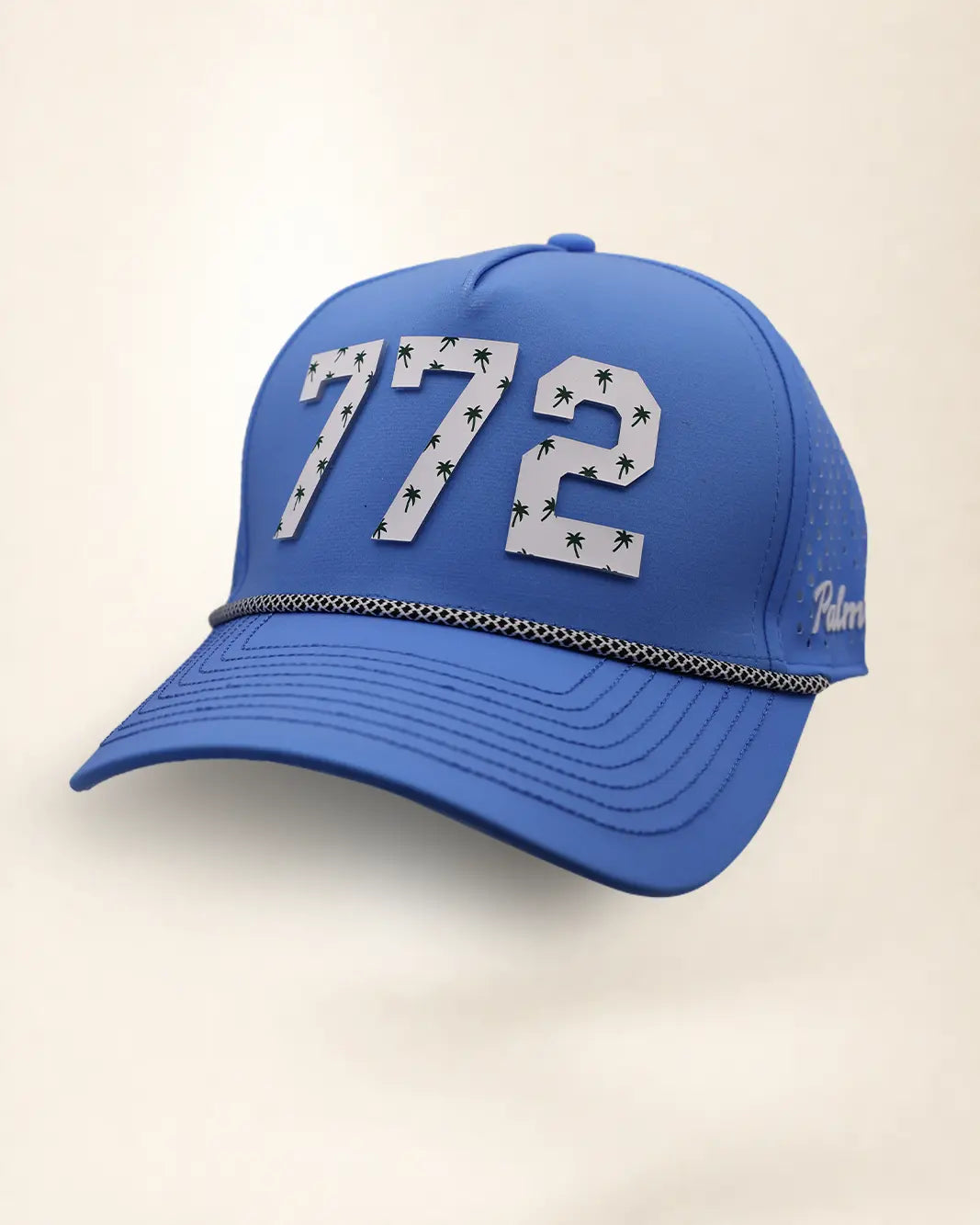 The 772 Signature Hat (Blue), three-quarter view: white raised 772 with small palm print on a blue rope snapback, black and white rope, white Palmr script.