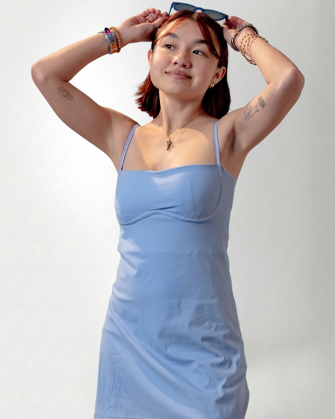 Woman wearing a light blue dress against a plain background