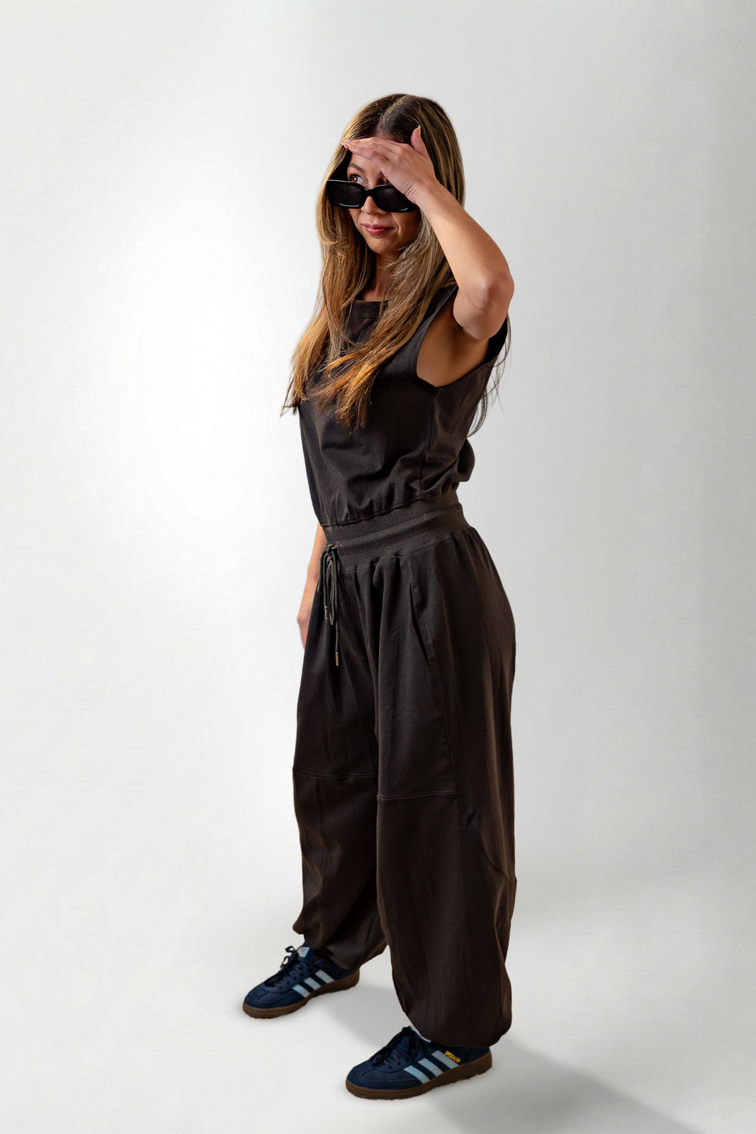 Woman wearing a black outfit with wide-leg pants on a white background