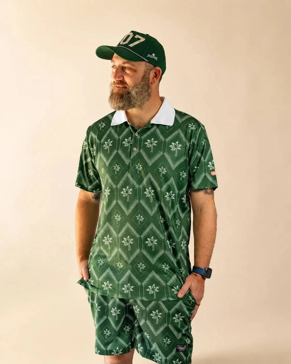 The Club Palm Polo in palm green with geometric diamond pattern and palm tree details, styled poolside on a sunny day