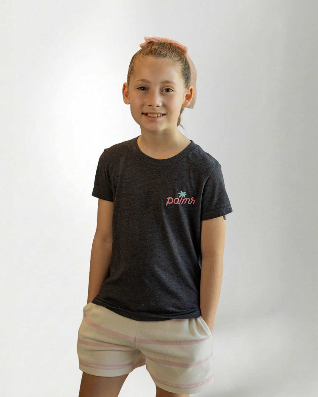 Child wearing a black t-shirt with a colorful graphic design, standing against a plain background.
