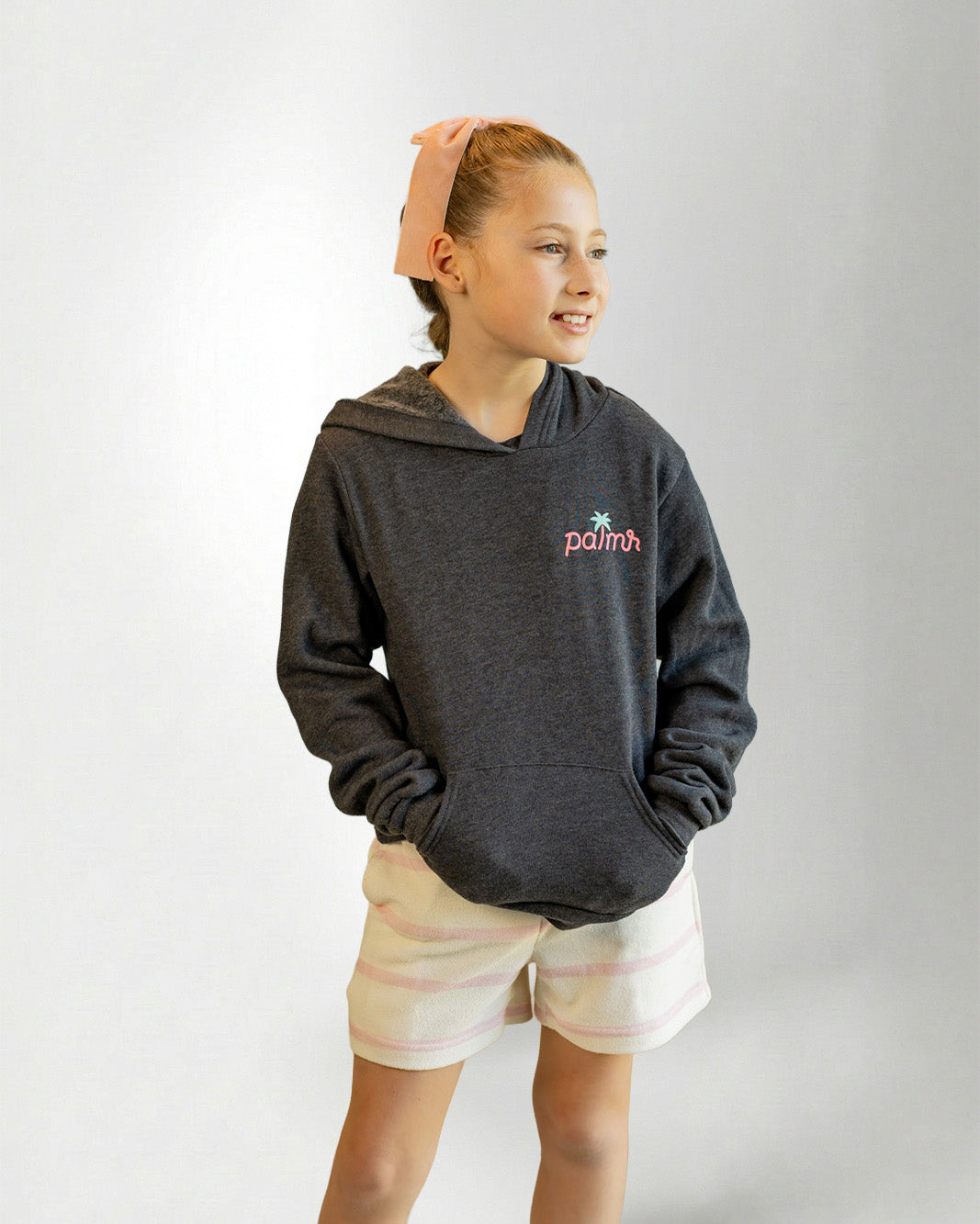 Person wearing a hoodie with a Palmr logo, standing against a plain background.