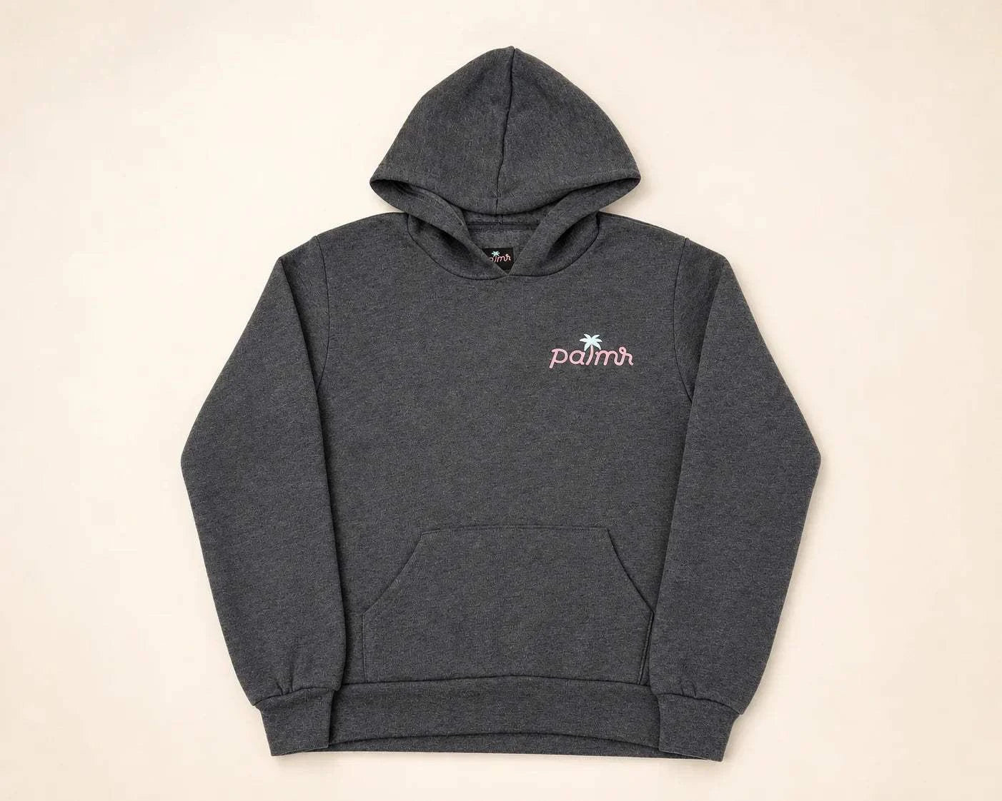 Child wearing The Evening Palm Kids Hoodie in dark heather grey with sunset graphic on back