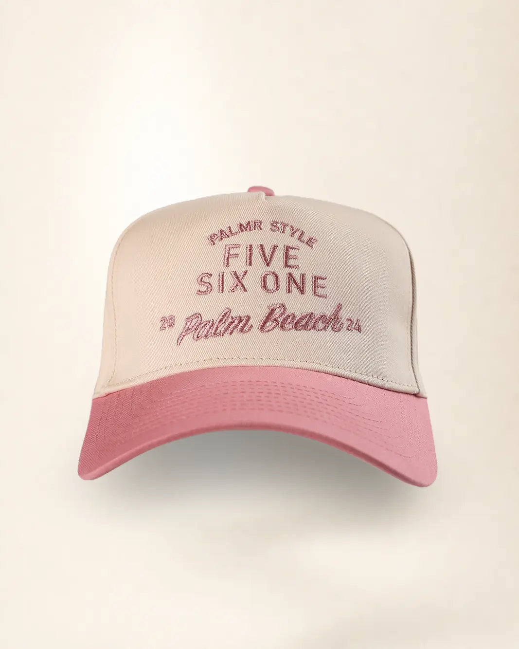 A two-tone baseball cap with a light beige crown and a pink brim, featuring pink embroidered text that reads 'PALMR STYLE FIVE SIX ONE 2 Palm Beach 25'.