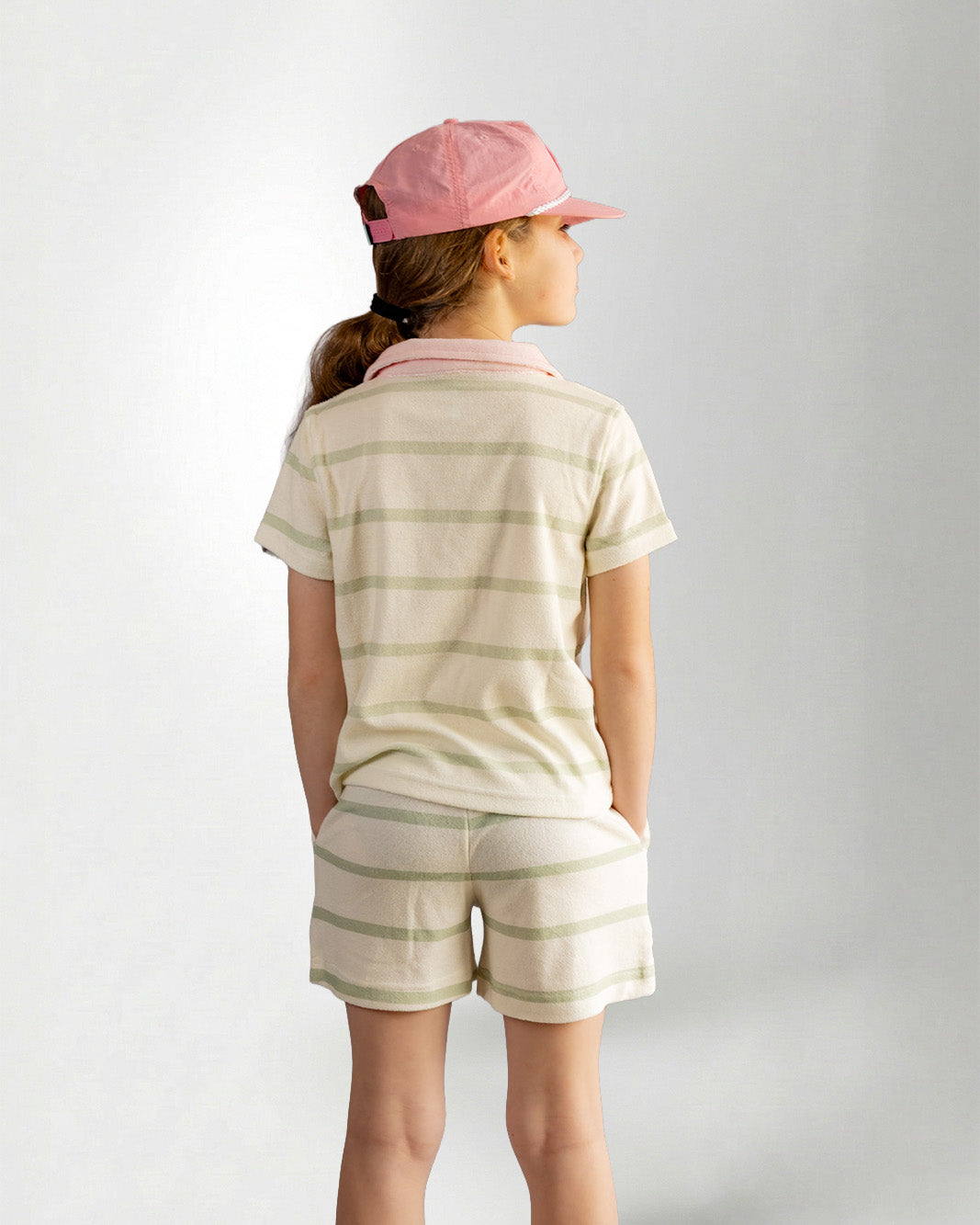 Girl wearing green striped shorts and shirt with palmr branding