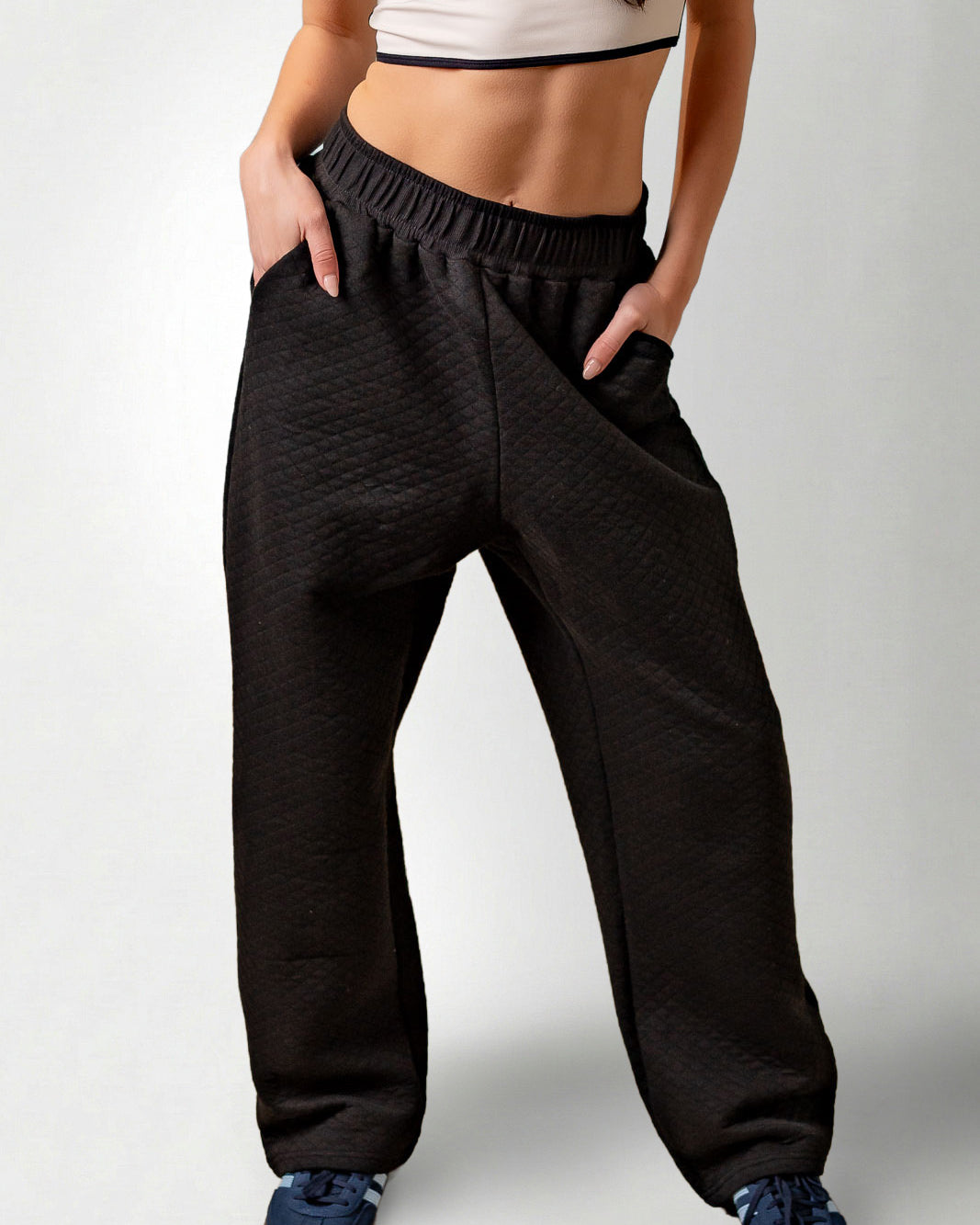 Person wearing black high-waisted pants on a white background