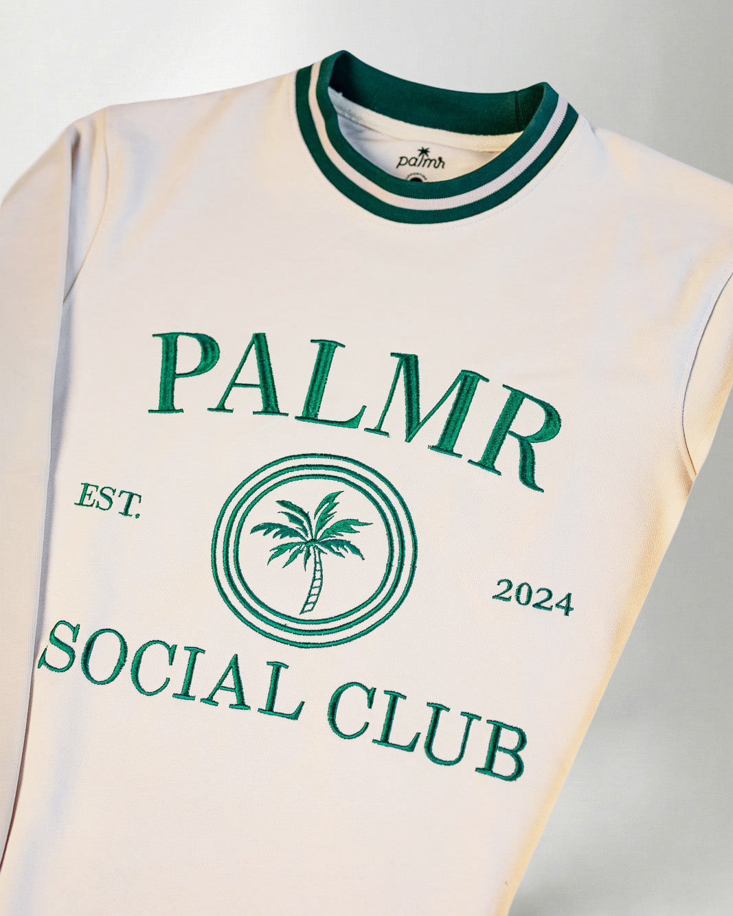 cream-colored sweatshirt with 'Palmr Social Club' branding on a light gray background