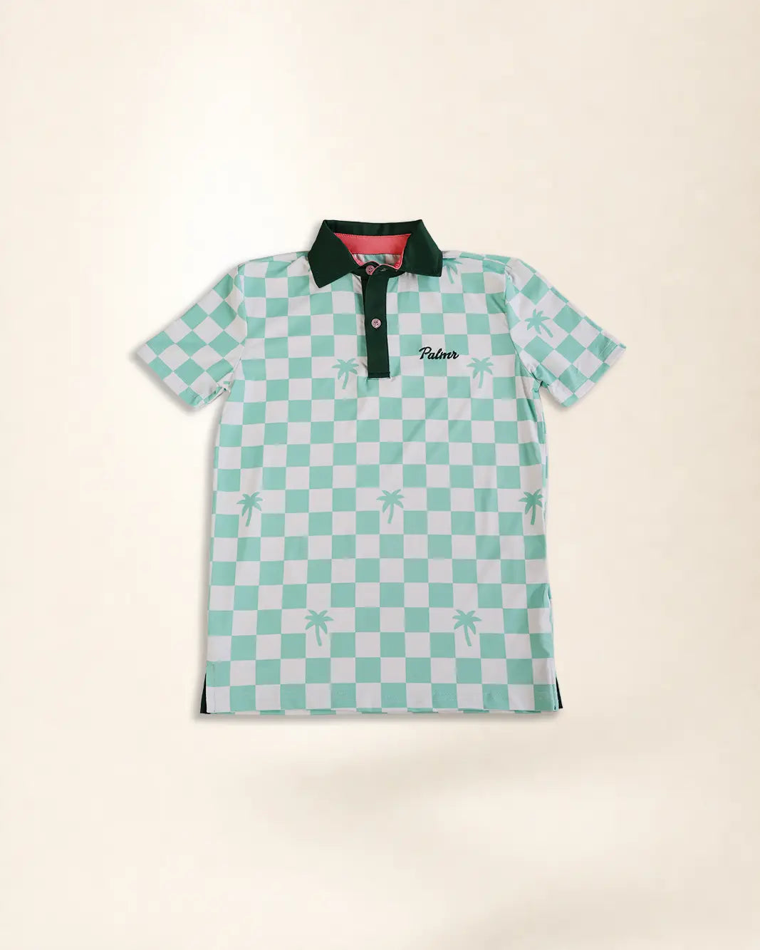 A short-sleeve polo shirt featuring a mint green and white checkered pattern with small palm tree motifs, a dark green collar, and a green embroidered 'Palmr' logo on the chest, displayed flat against a light beige background.