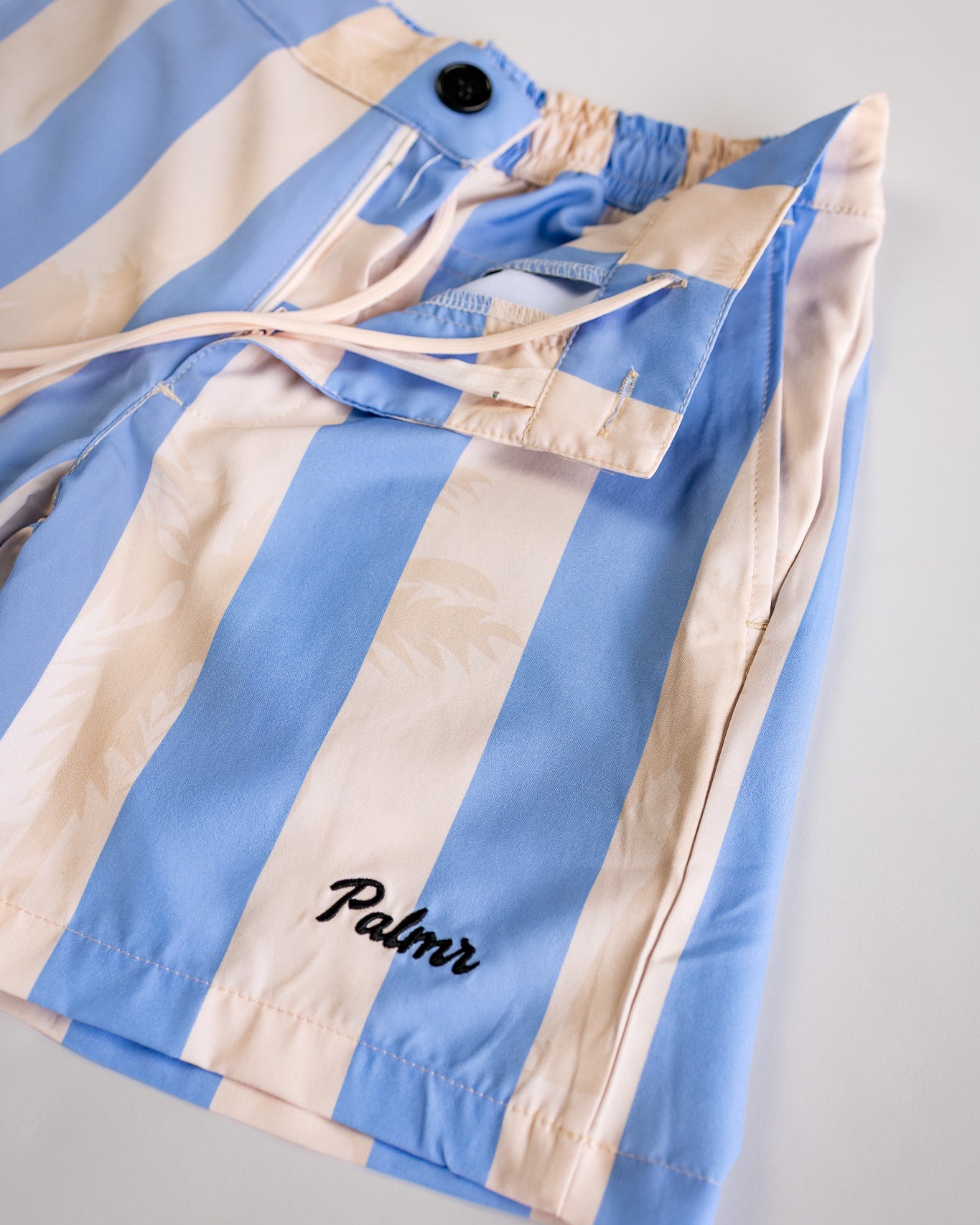 Blue and beige striped jacket with 'Palmr' branding on a light gray background
