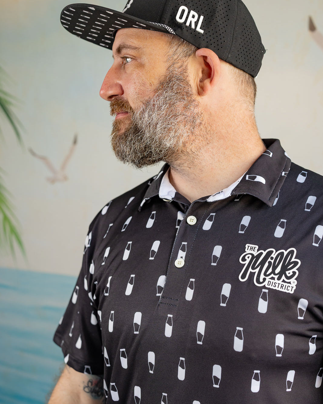Man wearing a black cap with 'ORL' and a black shirt with white graphics and text.