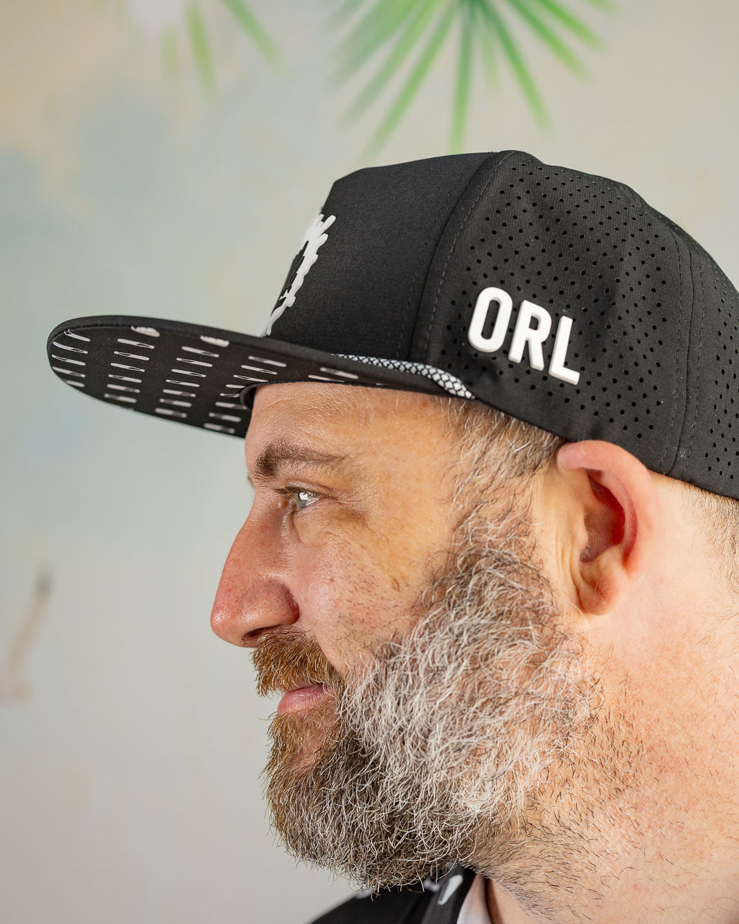 Man wearing a black cap with 'ORL' on it, against a blurred outdoor background.