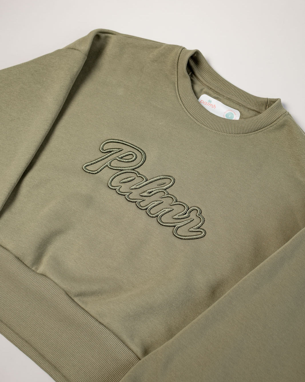 Olive green sweatshirt with 'Palmr' embroidery on a light gray background