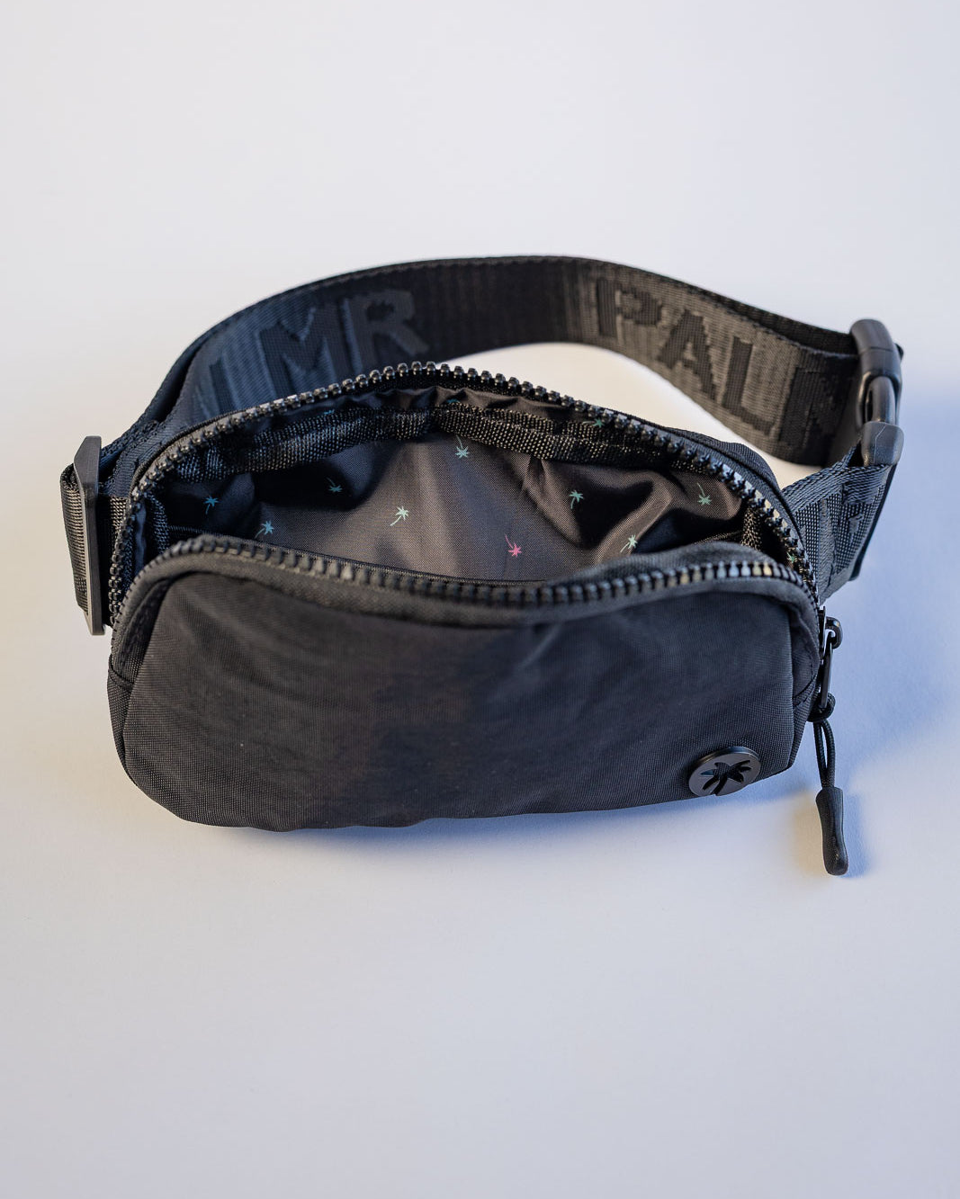 Black waist bag with visible branding on a white background
