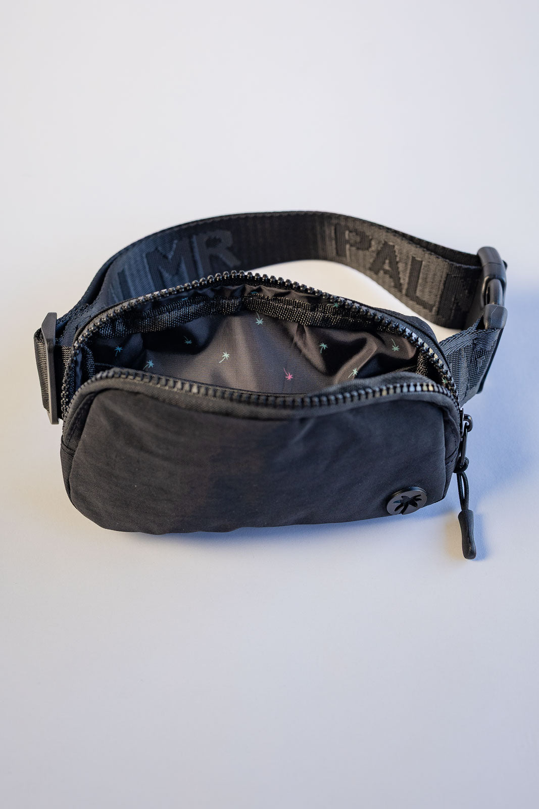 Black waist bag with visible branding on a white background