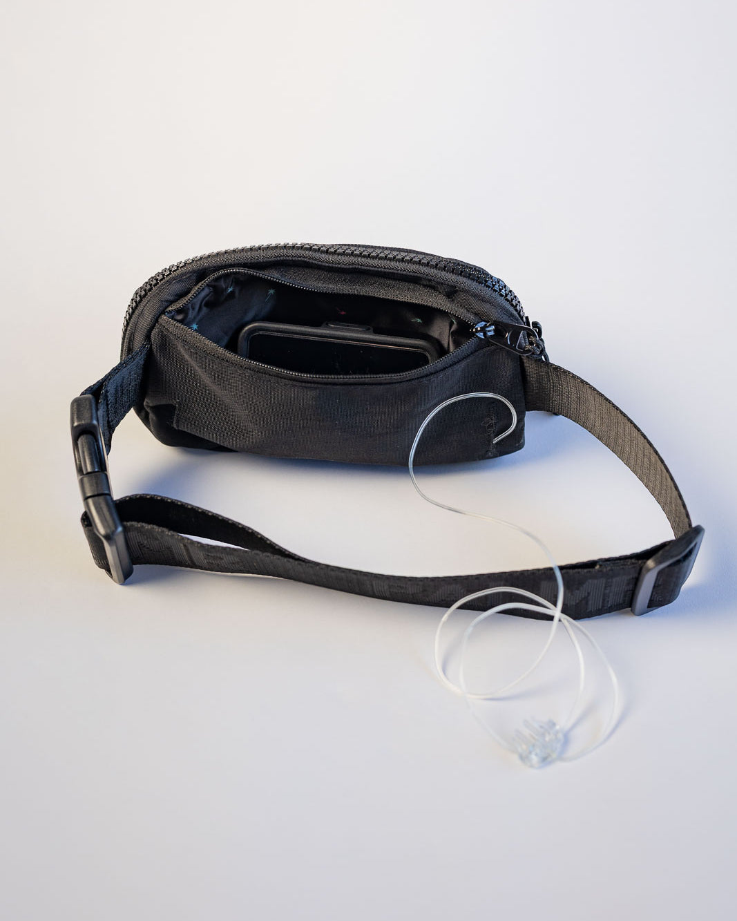 Black waist bag with a strap on a white background