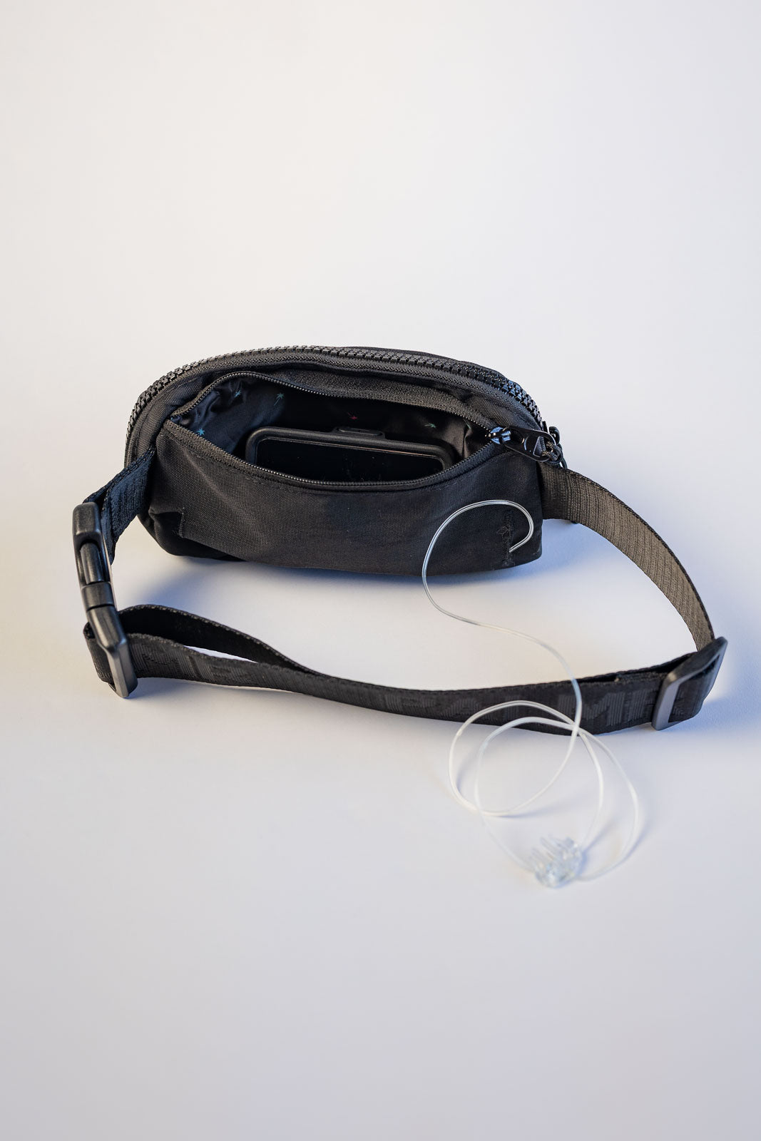 Black waist bag with a strap on a white background