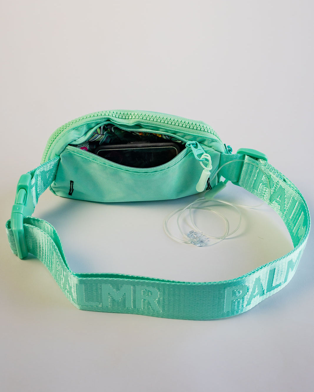 Turquoise dog collar with visible branding on a light gray background