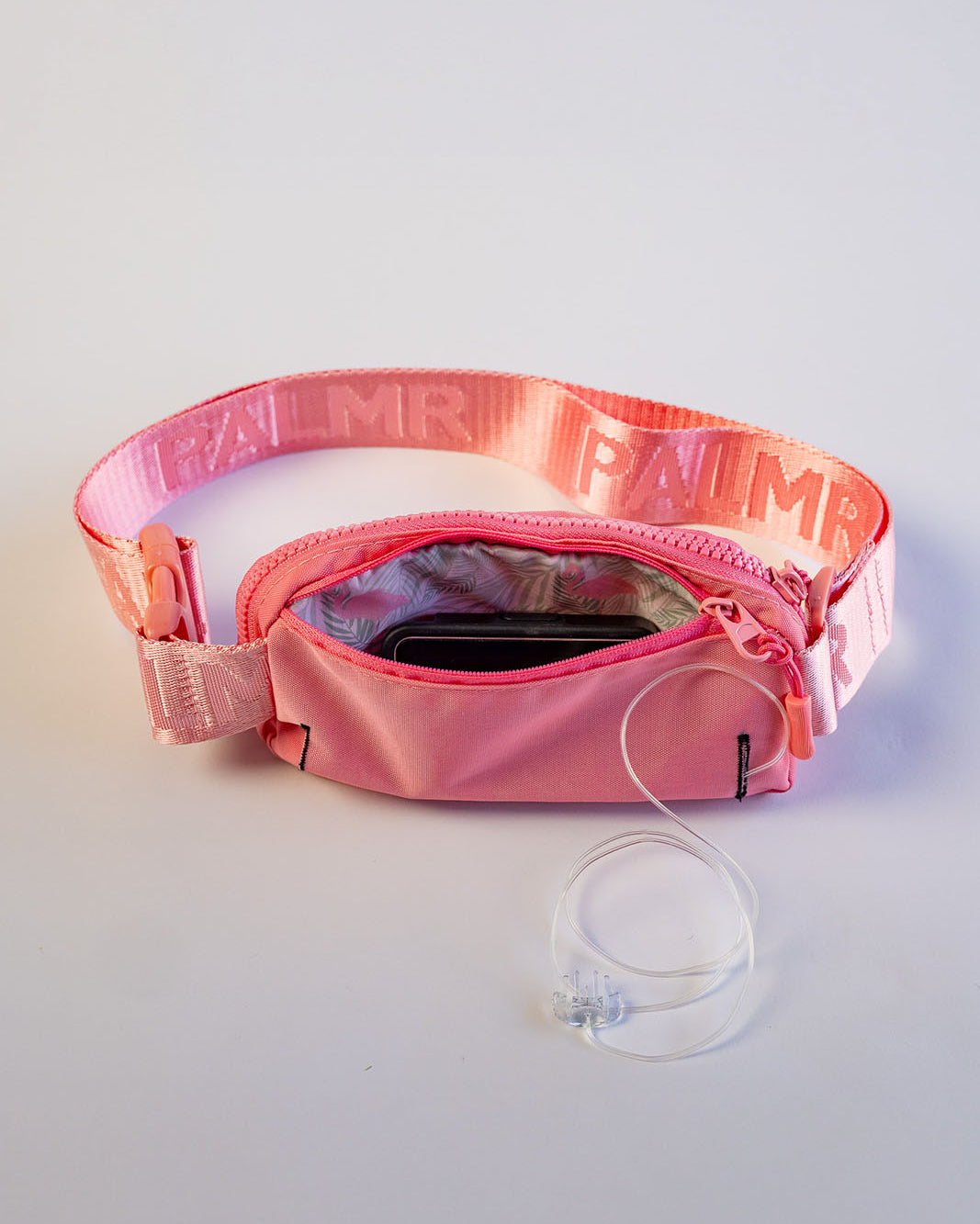 Pink waist bag with a clear strap on a light gray background