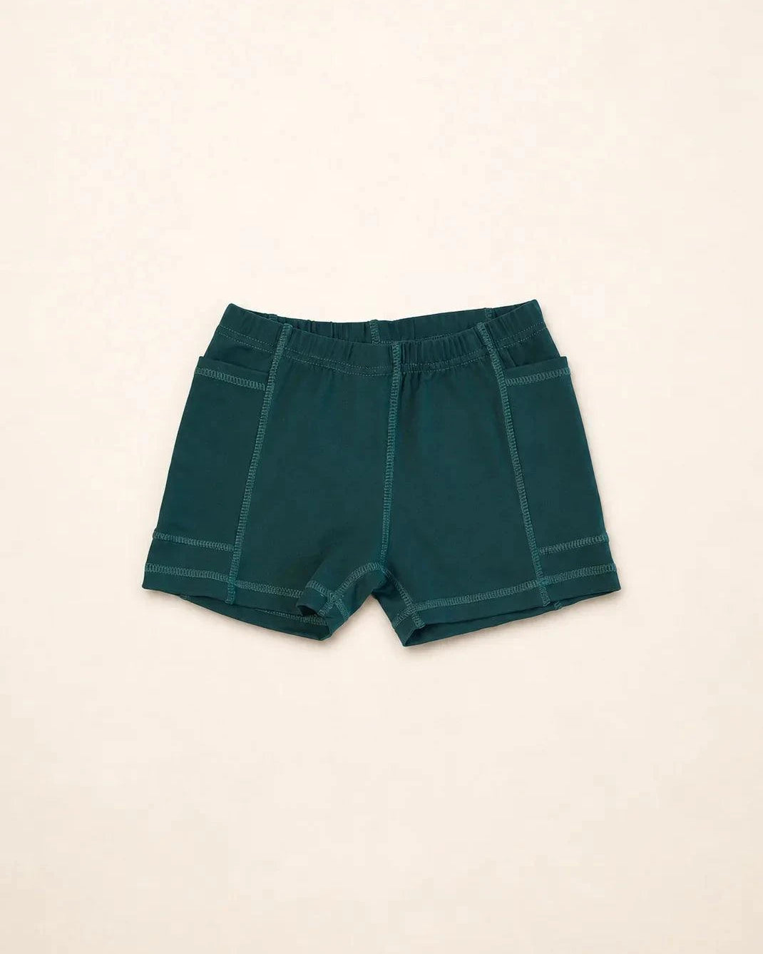 The Ace Kids Dress in palm green with pink and teal mini palm tree print, featuring pump-friendly shorts with discreet slits and pockets.