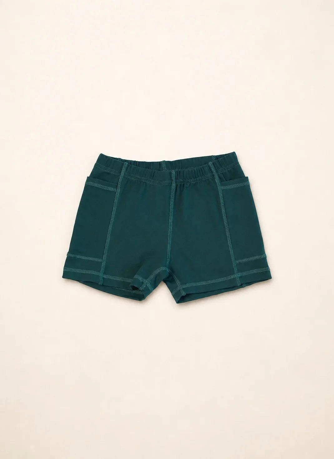 The Ace Kids Dress in palm green with pink and teal mini palm tree print, featuring pump-friendly shorts with discreet slits and pockets.