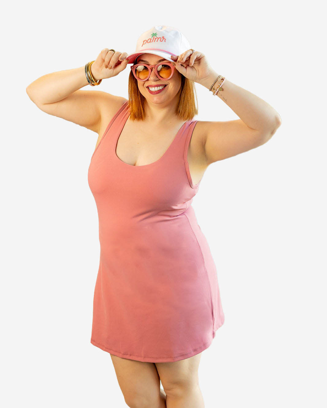 Woman wearing a pink dress and white cap with red text on a white background