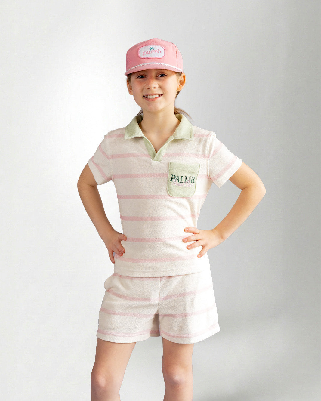 Girl wearing green striped shorts and shirt with palmr branding