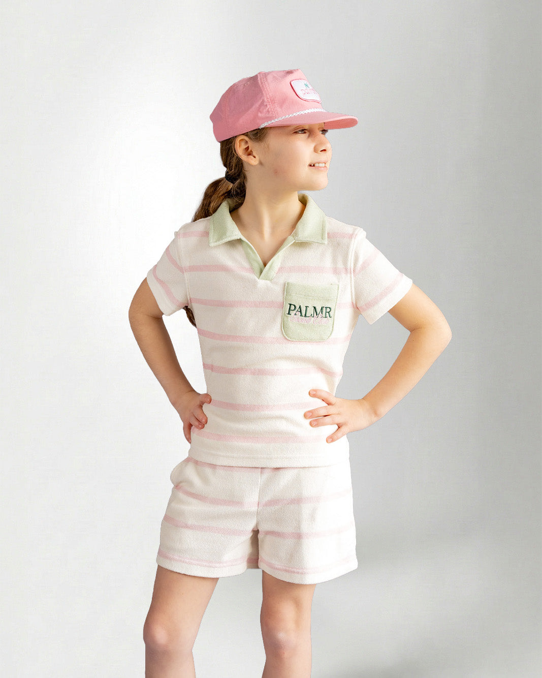Girl wearing green striped shorts and shirt with palmr branding