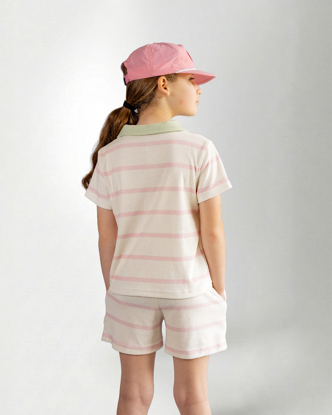 Girl wearing green striped shorts and shirt with palmr branding