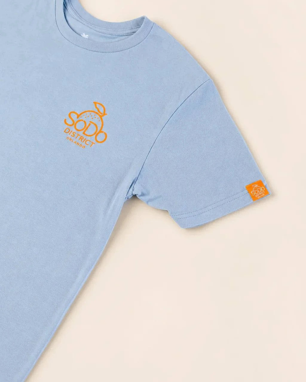 Blue SoDo Neighborhood Tee with orange logo and neighborhood icons promoting local pride and community support