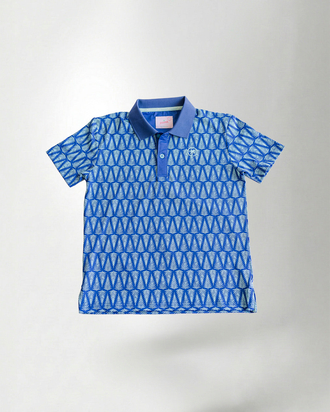 Child wearing a blue patterned polo shirt and cap with a white background