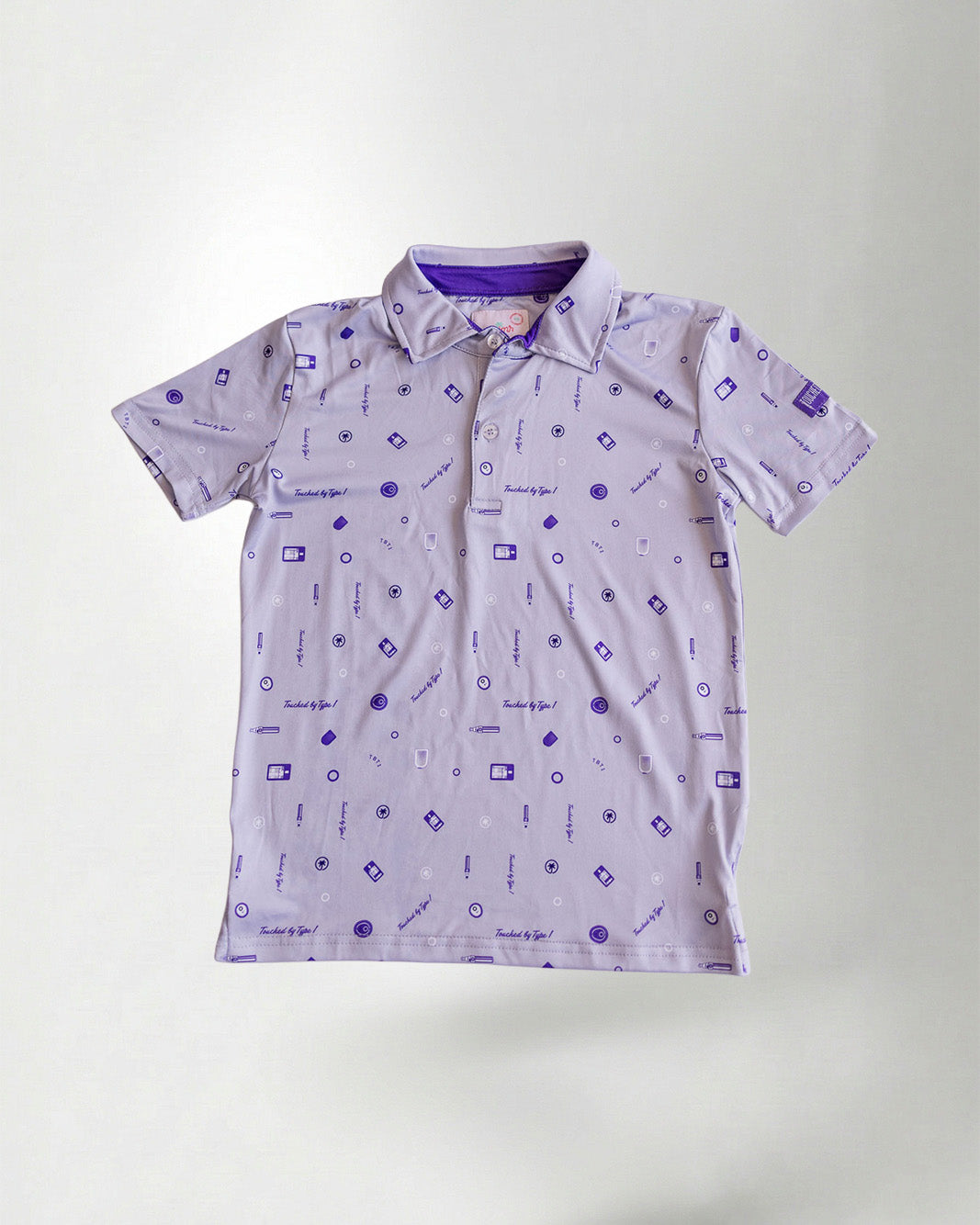 Patterned polo shirt and cap on a plain background