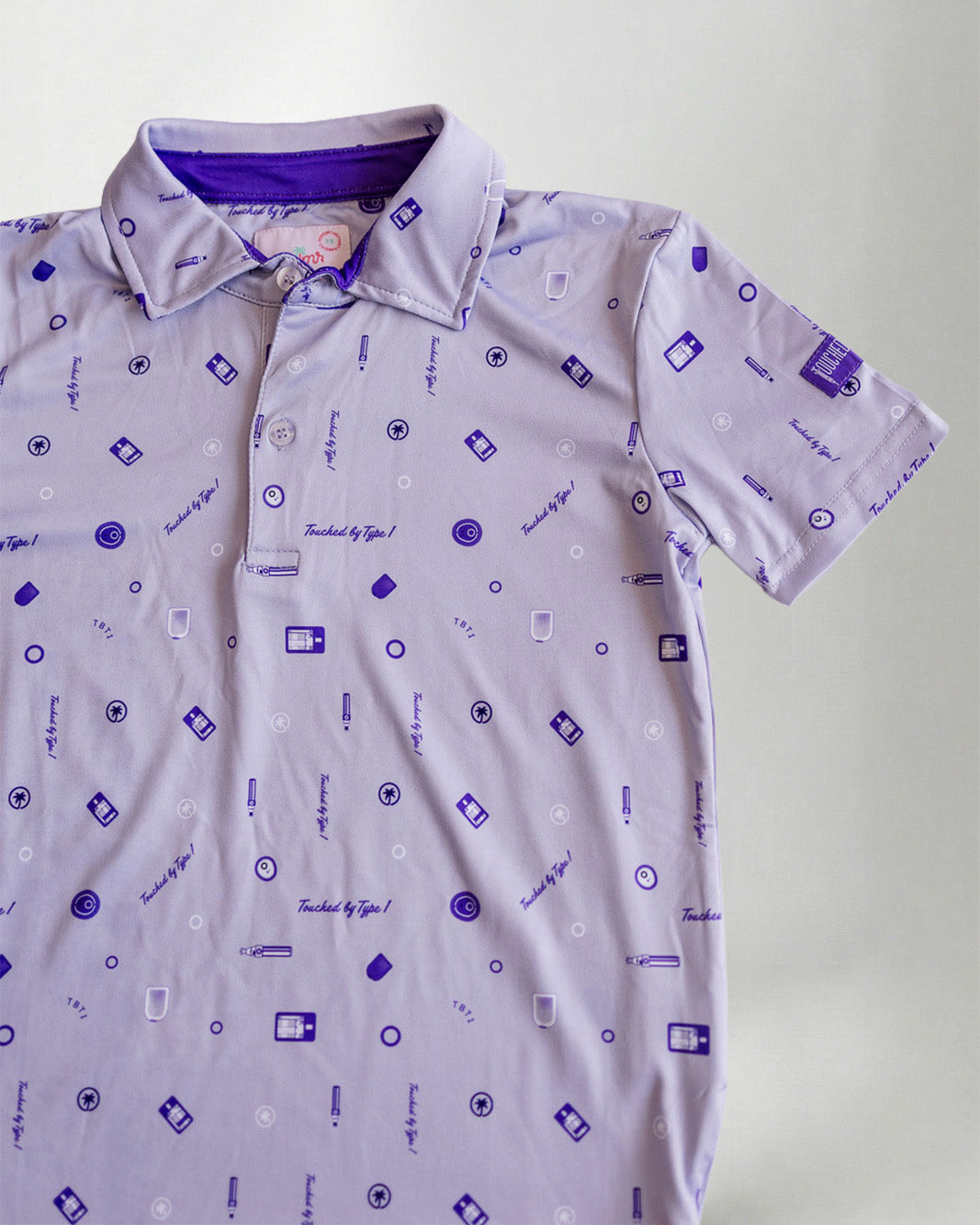 Child wearing a patterned polo shirt and cap on a plain background