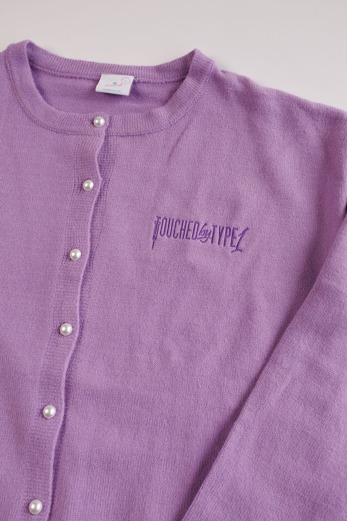 Purple "Touched by Type 1" cardigan against gray background.
