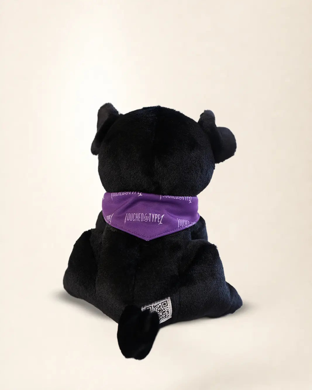 Basal Dog Plush, a black Labrador plush wearing a purple Touched By Type 1 bandana and a Basal name tag