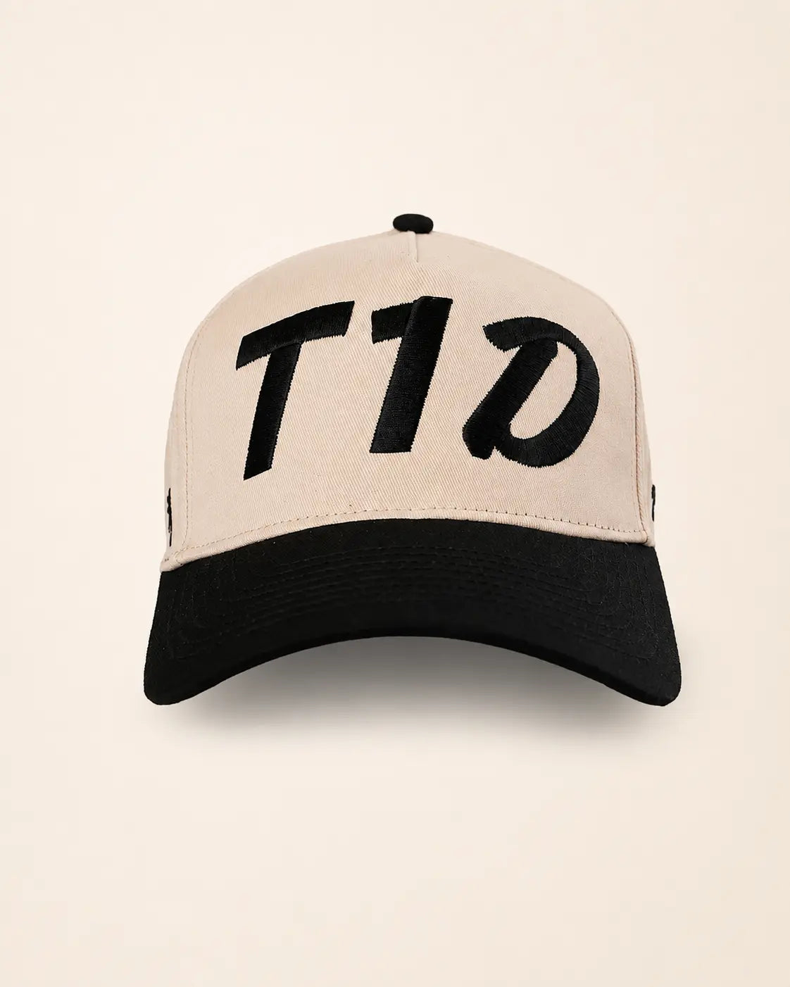 A structured baseball cap with a light beige crown and a black curved brim, featuring the stylized text 'T1D' embroidered in black across the front panels.
