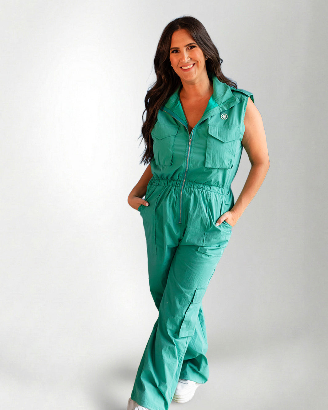 Woman wearing a green jumpsuit on a gray background