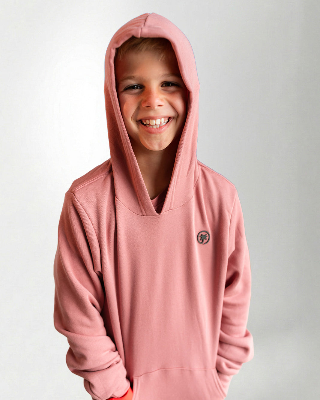 Child wearing a pink hoodie with a small logo on a light gray background