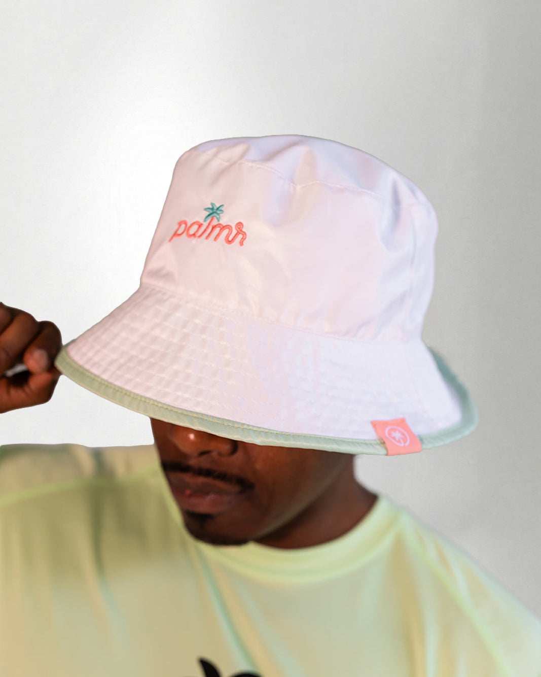 White bucket hat with a "Palmr" logo in embroidery