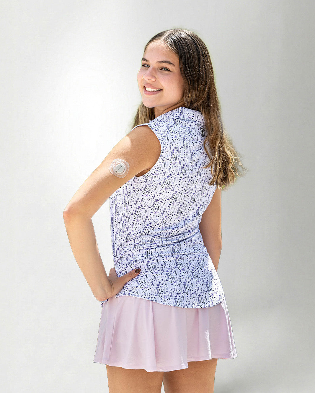 Woman wearing a patterned sleeveless polo and a skirt