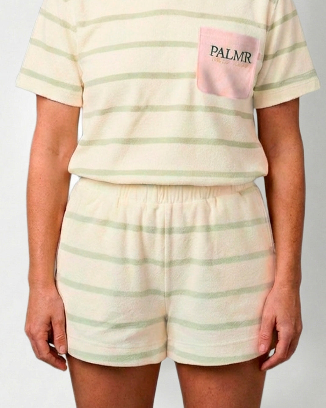 Person wearing a striped polo shirt and shorts with 'PALMR' branding.