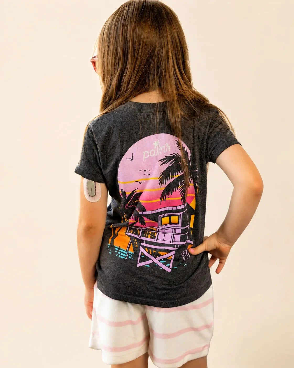 Kids black mineral wash Evening Palm tee with beach sunset graphic and Palmr logo