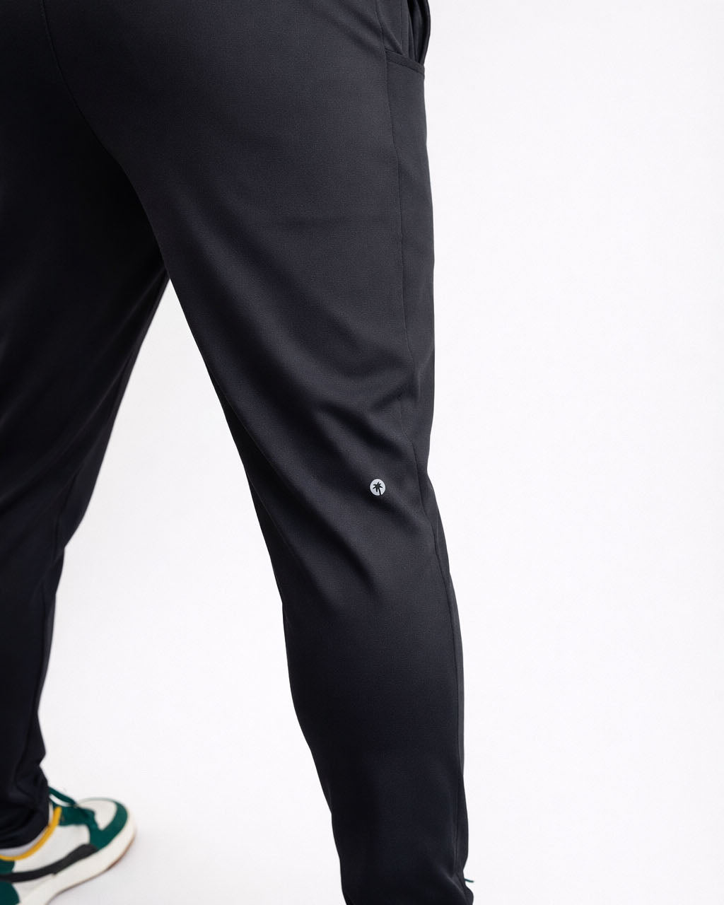 Black pants worn by a person on a white background