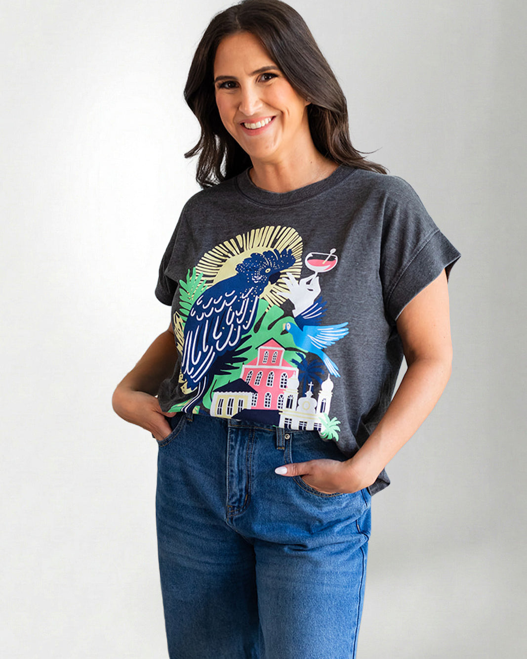 Woman wearing a graphic t-shirt with a colorful design on a plain background