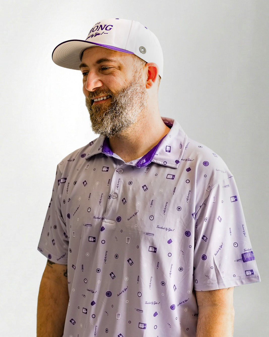 Man wearing a patterned shirt and cap against a plain background